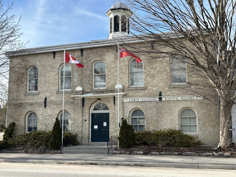 Alnwick/Haldimand Town Hall, an elegant structure with classic architectural lines and a prominent clock tower, set against a serene sky in Ontario.