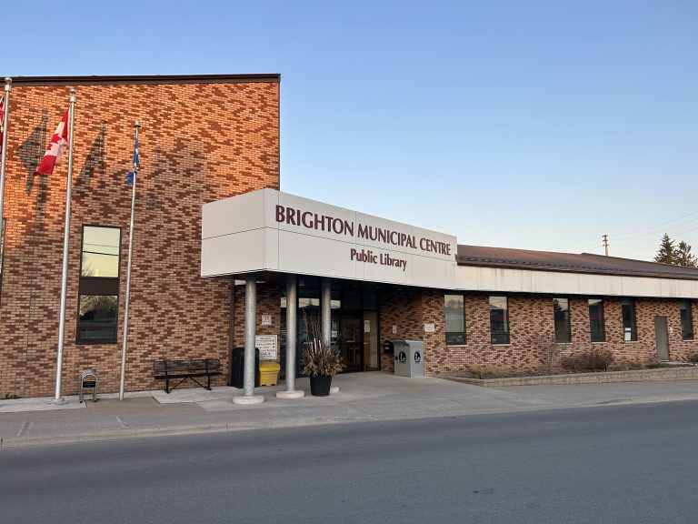 Brighton Township Real Estate: Brighton Municipal Building II combines traditional and modern architectural elements with its brick structure and large, inviting windows, set against a backdrop of mature trees in Brighton.